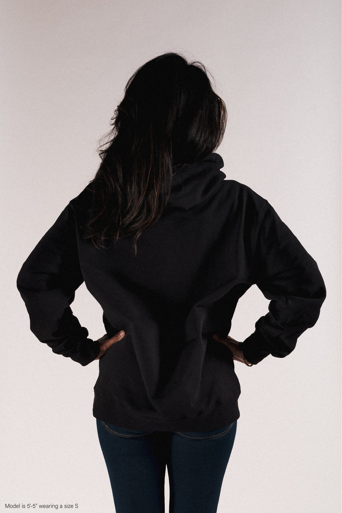 Title MTB black pullover hoodie minimal logos, behind view, shown on female model 